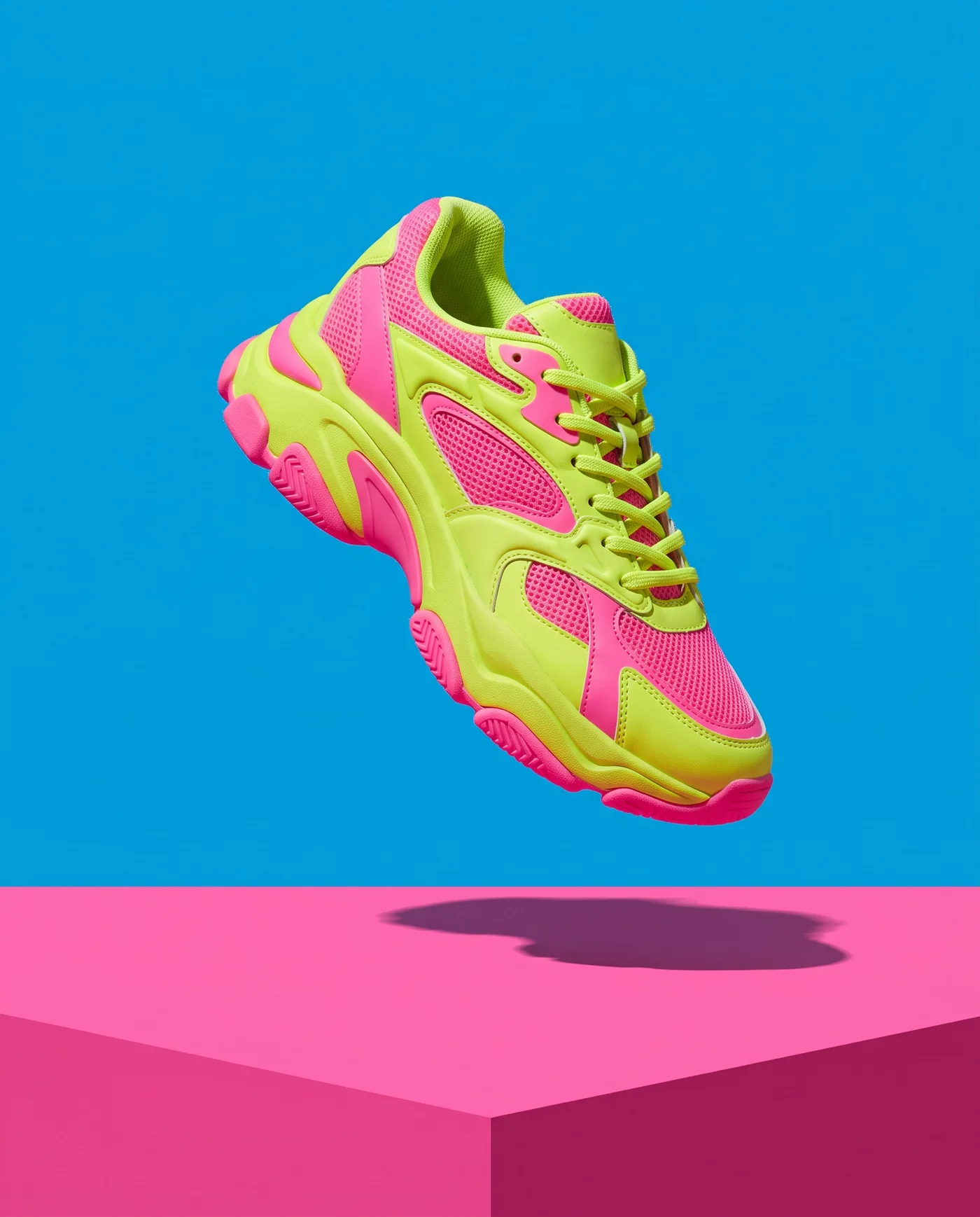 A neon sneaker on a pink plinth, made with Hero_Photo