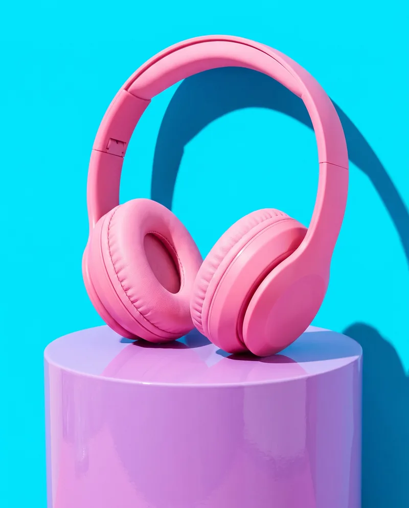 Pink headphones on a lilac plinth